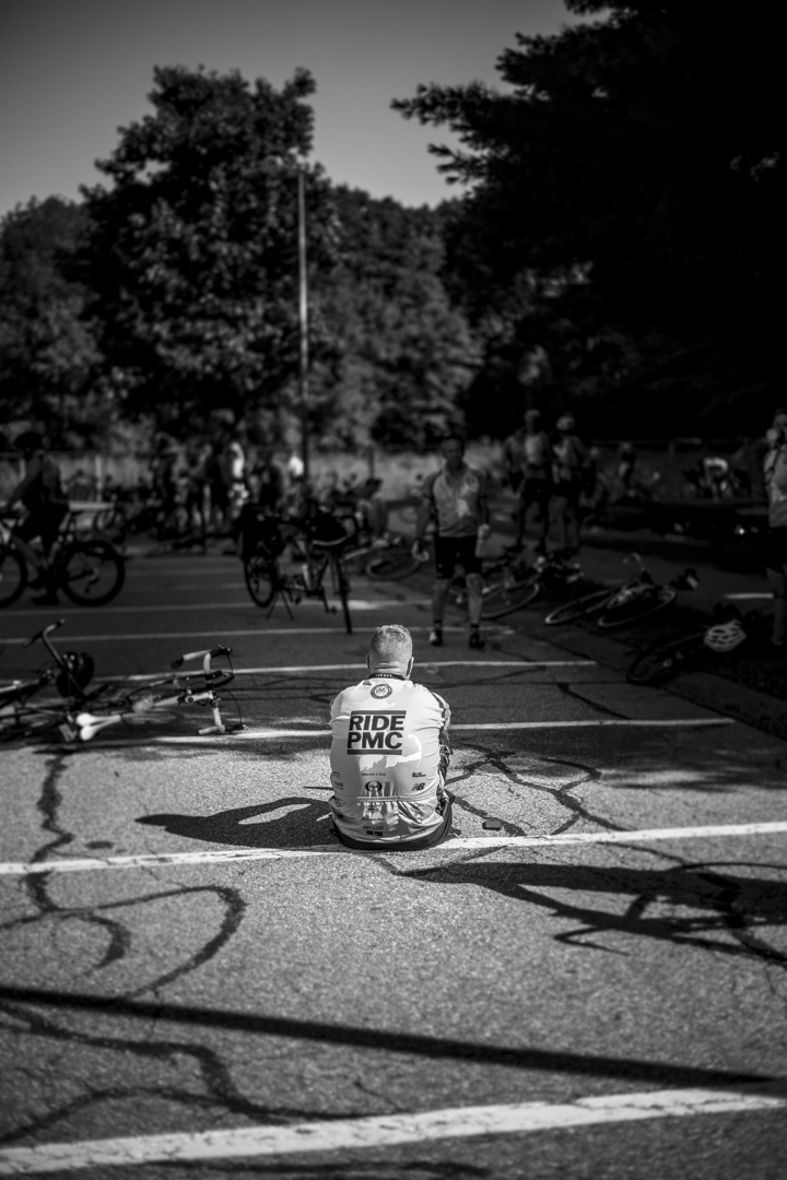 A cyclist sits on the ground during the Pan Mass Challenge 2022