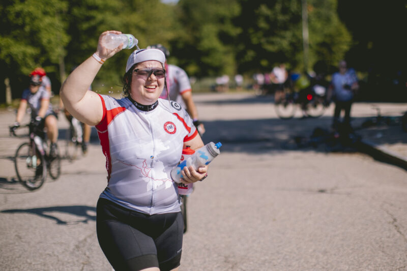 A cyclists cools themselves with water during the Pan Mass Challenge 2022